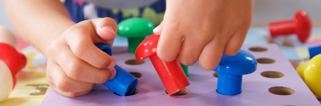 A child's hands playing with toys