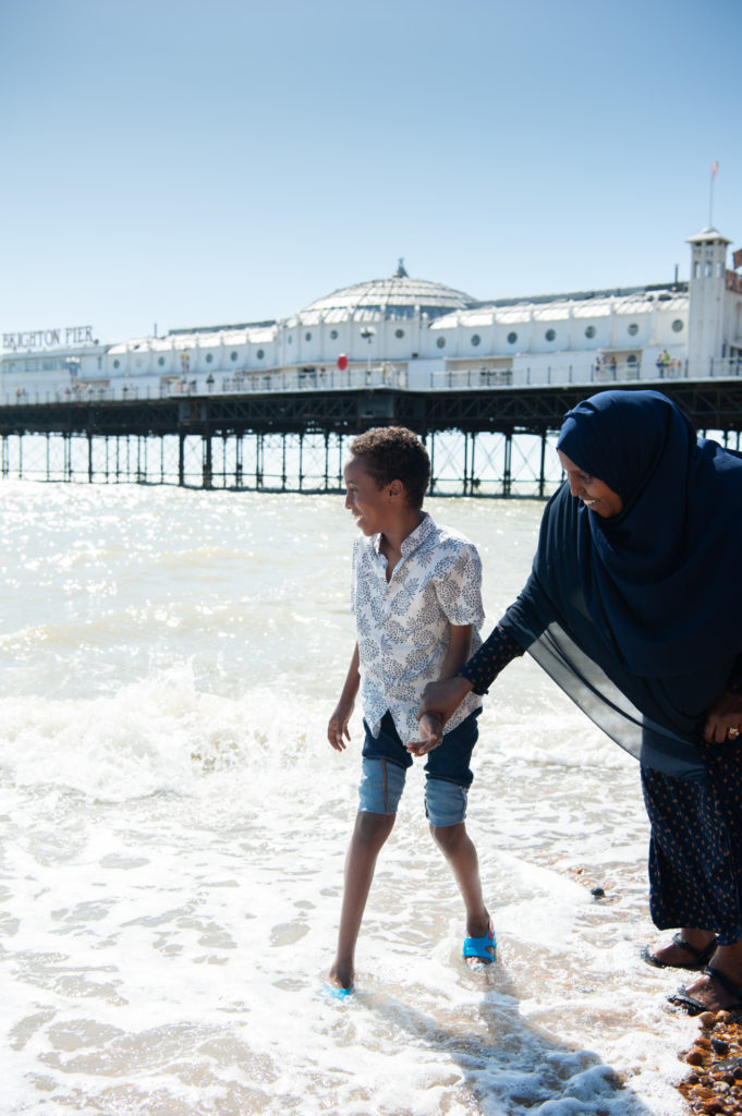 Child and mum on Brighton beach paddling in the sea
