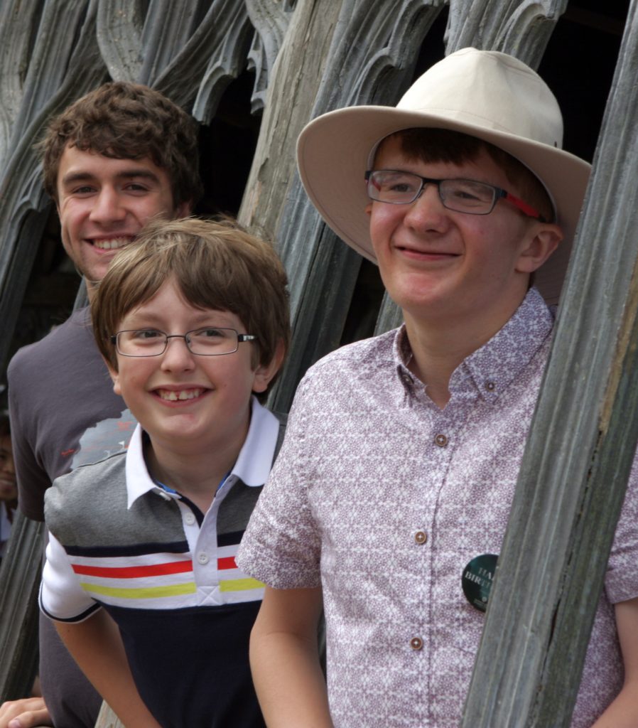 Dad and two teenage children smiling at the camera