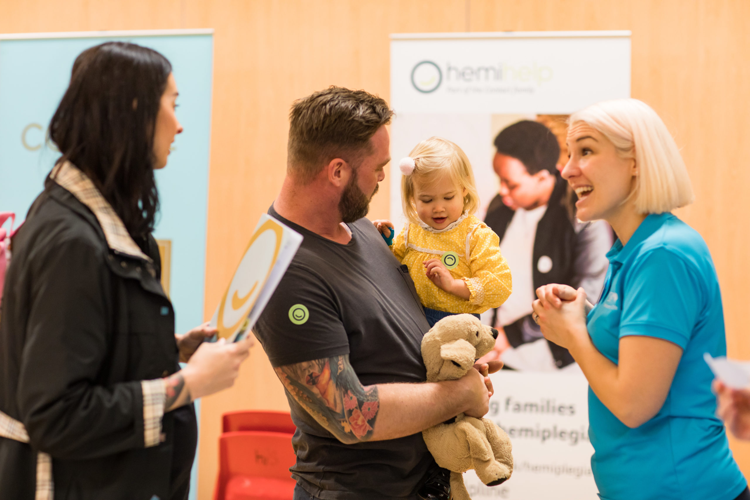 HemiHelp event - parents with young child talking to Contact team member