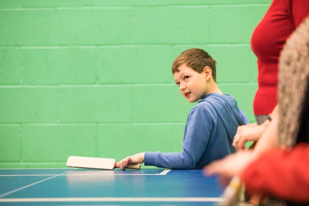 HemiHelp event - child in blue hoodie top, holding table cricket bat