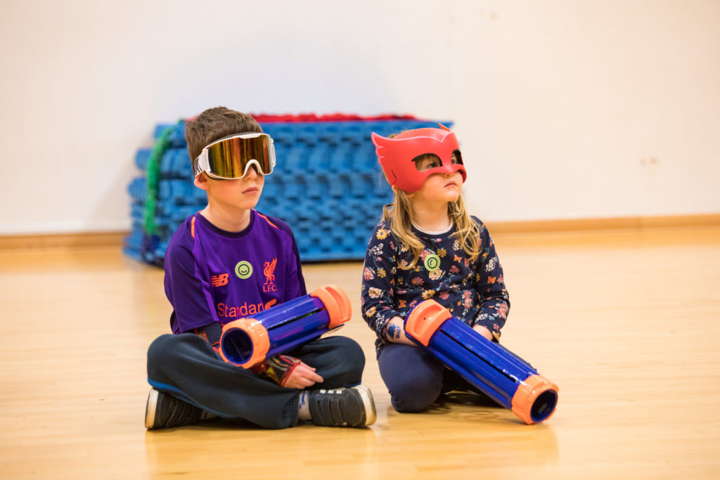 HemiHelp event - 2 children sitting on floor with foam ball shooters