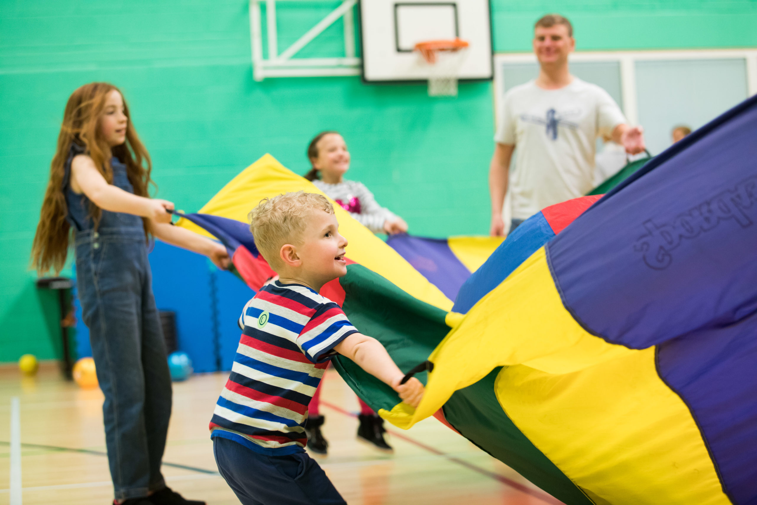 HemiHelp event - children and adult playing with colourful parachute play tent
