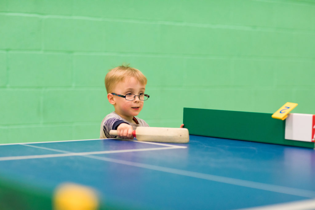 HemiHelp event - boy wearing glasses and stripy top playing table cricket