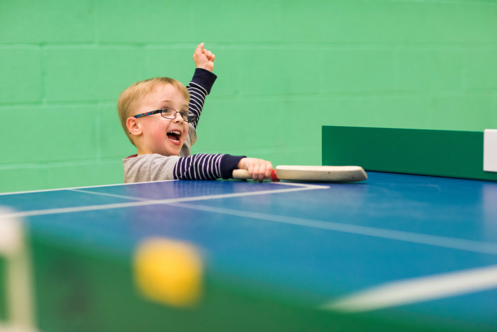 HemiHelp event - boy wearing glasses and stripey top playing table cricket