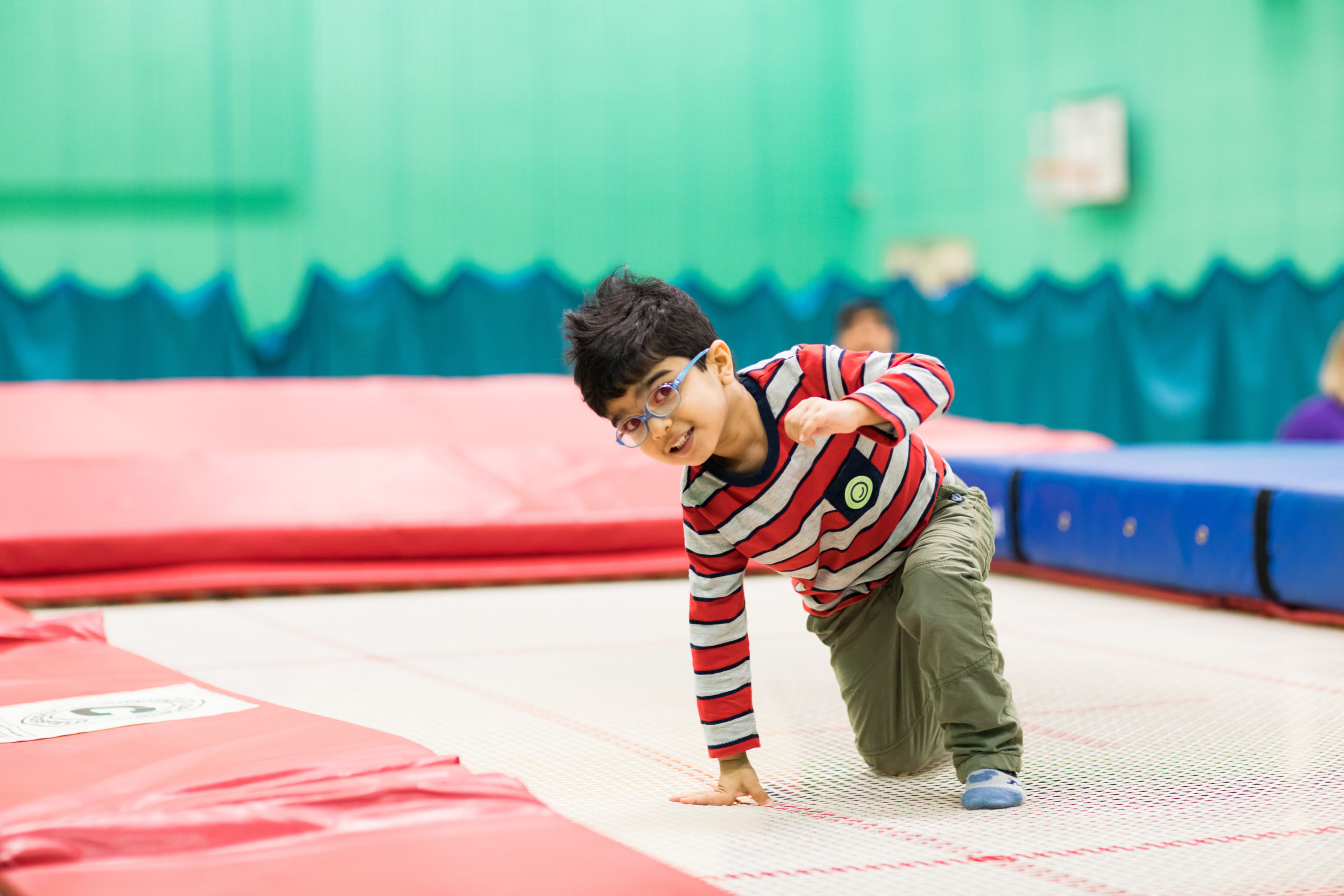HemiHelp event - boy wearing glasses and stripy top, standing on trampoline