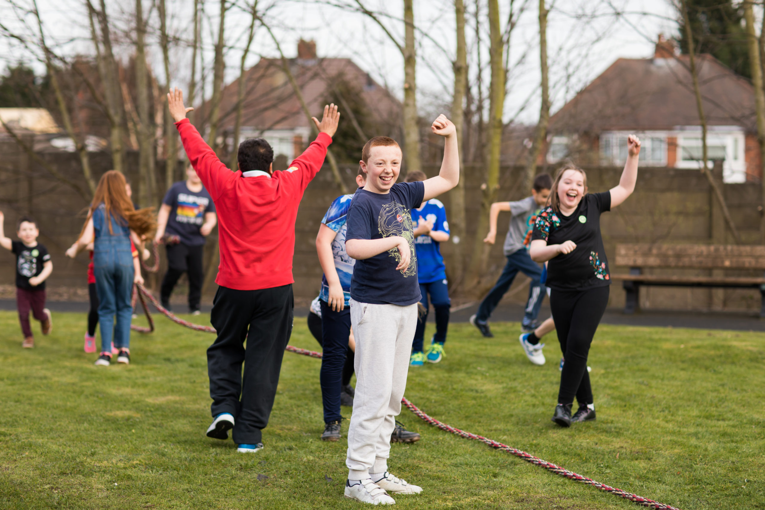 HemiHelp event - children outside with arms in air after winning game of tug'o'war