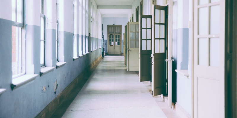 Classroom doors open to empty school hallway