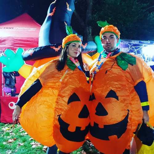 Couple dressed in inflatable pumpkin outfits at night