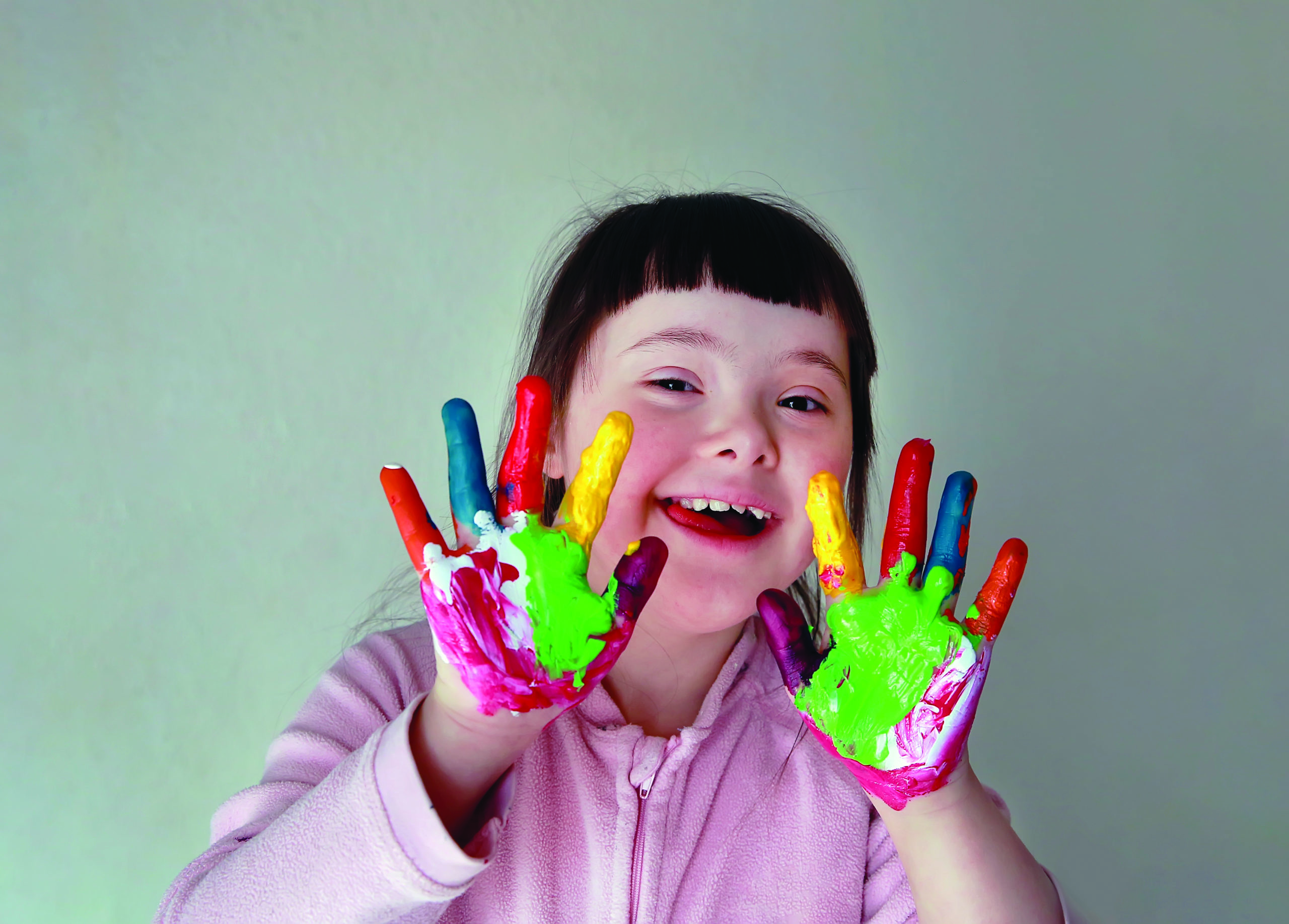 Cute child with painted hands. Isolated on grey background