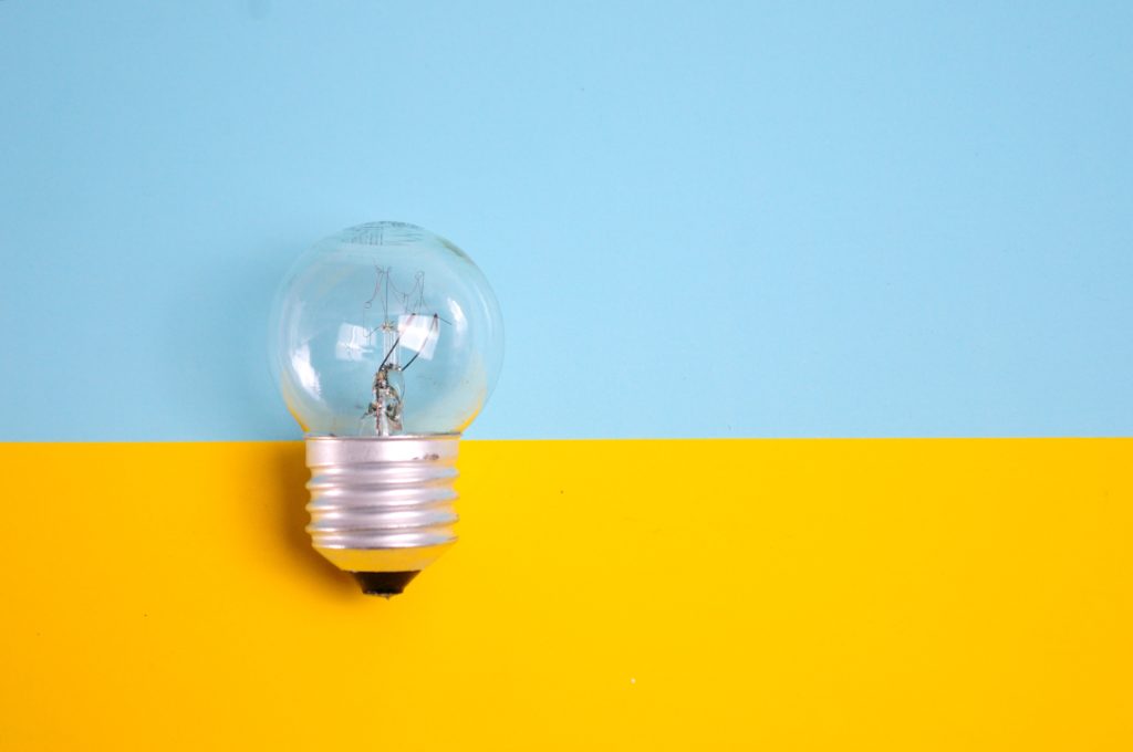 Light bulb on yellow and blue background