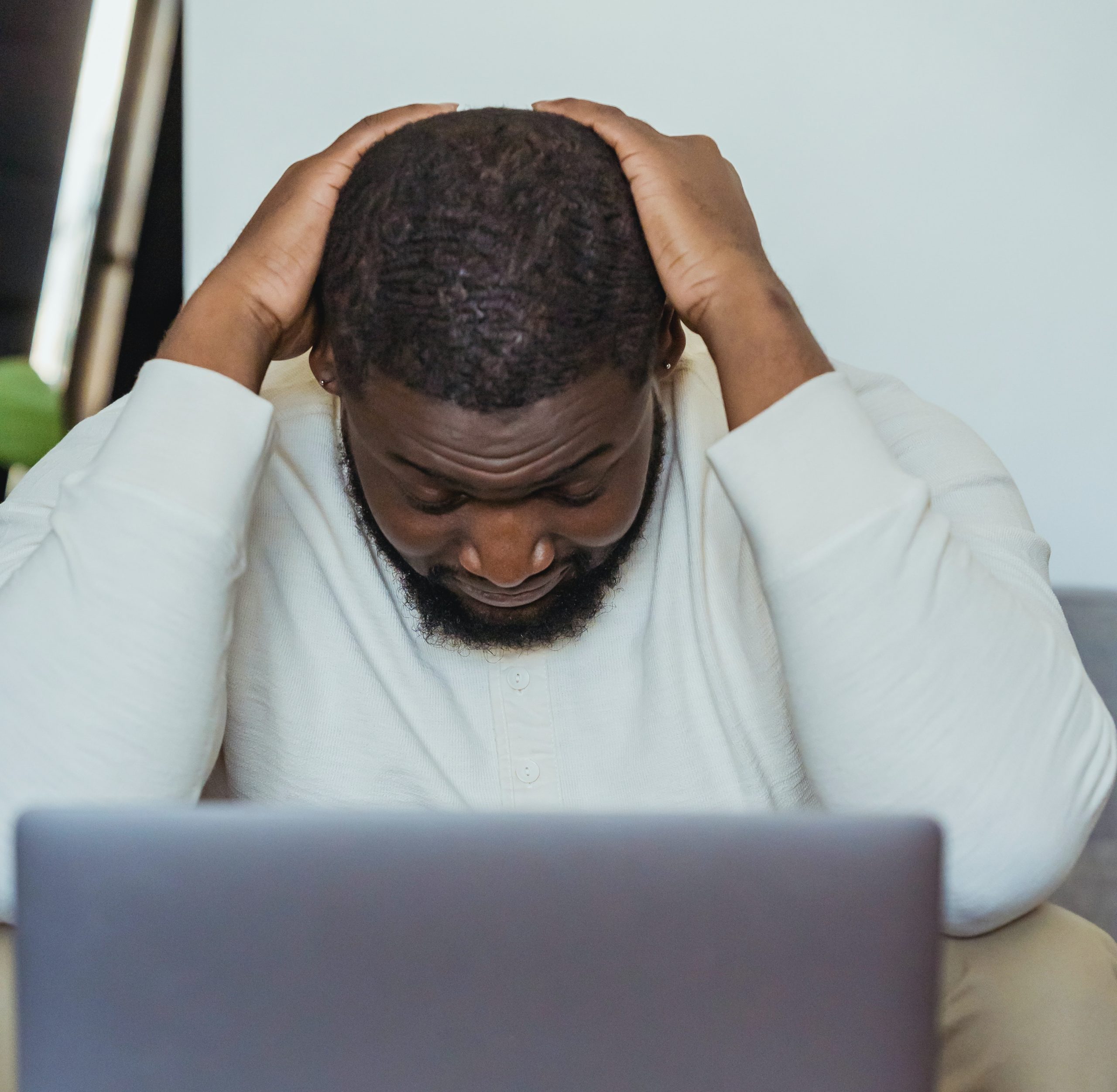 Stressed adult with head in hands