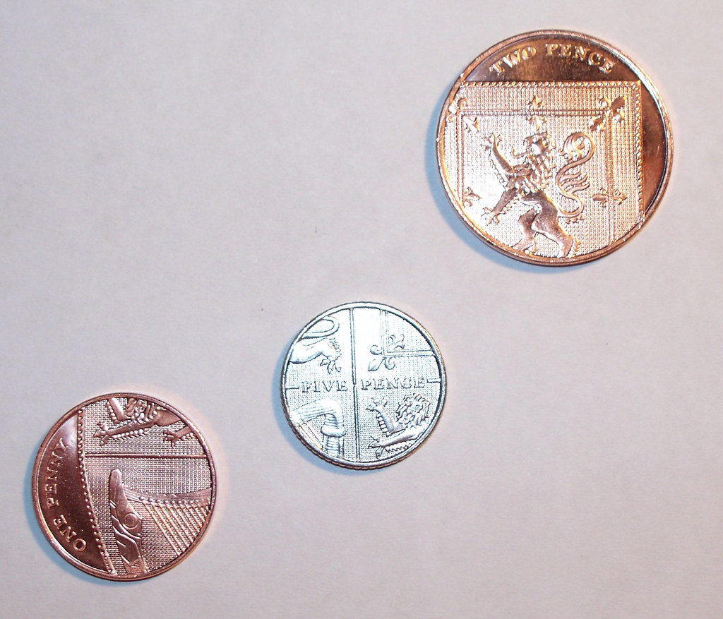 Shiny British coins on white background