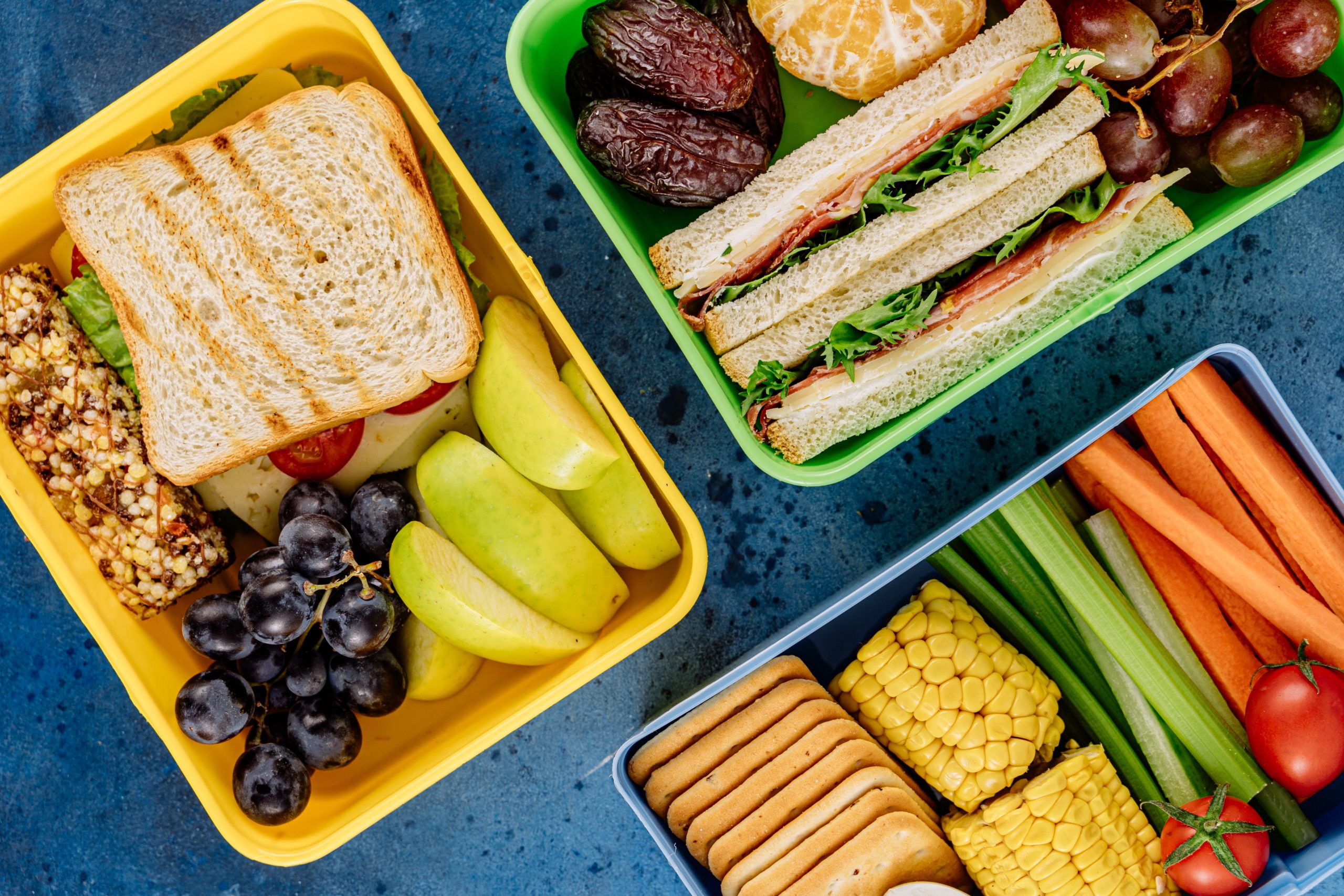 Lunchboxes filled with sandwiches, fruit, vegetables