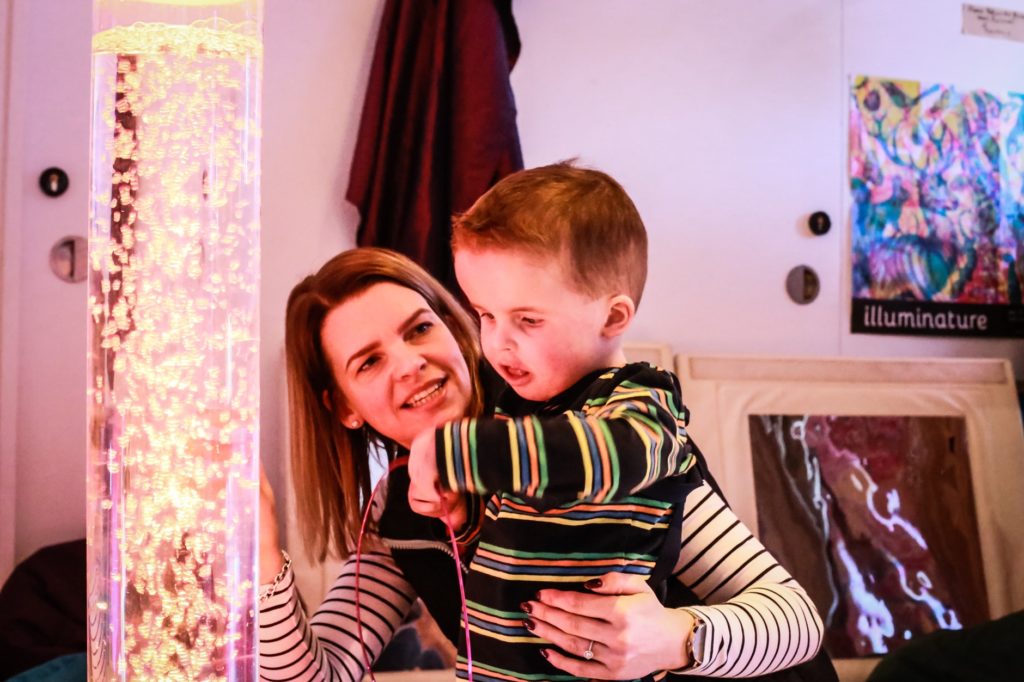 Child and parent looking at lava lamp