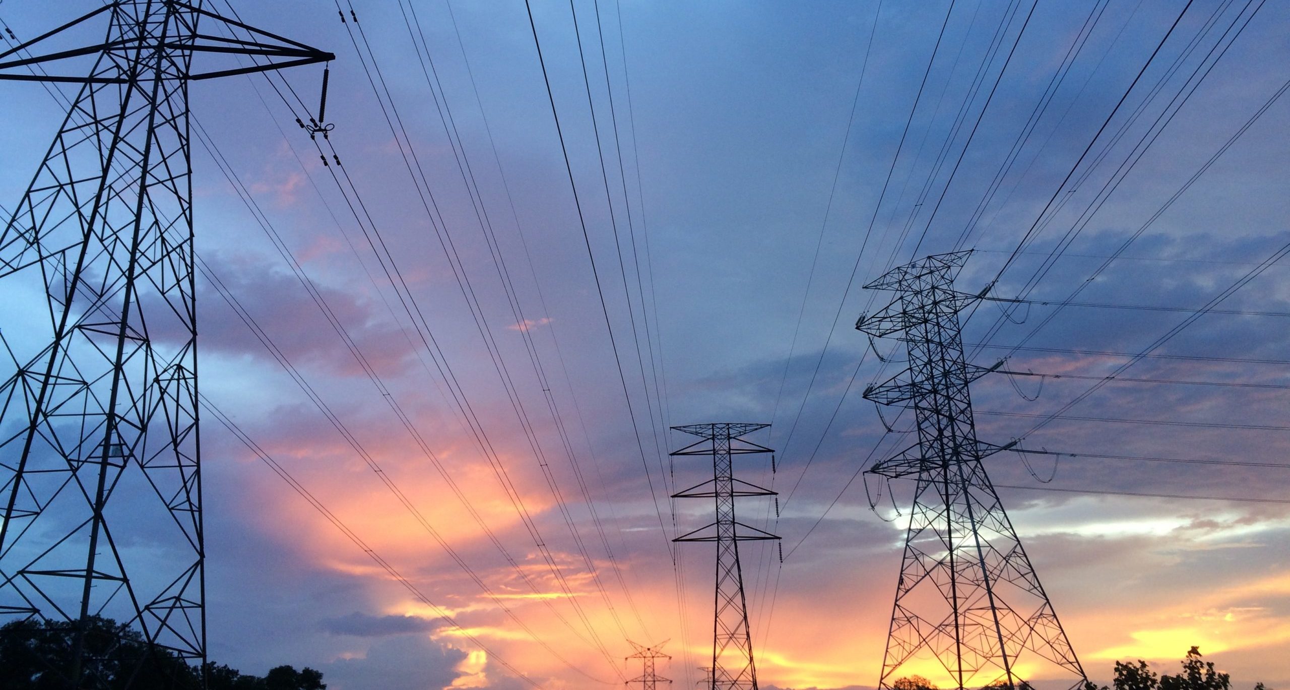 Electricity pylons in front of a sunset sky