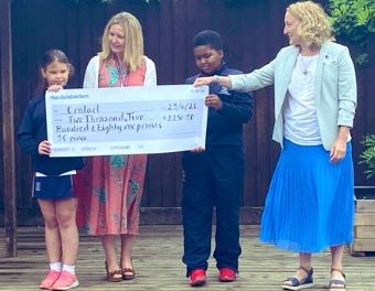 2 school pupils and their teacher present large cheque to HemiHelp staff member