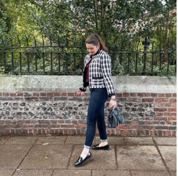 Chiara in a black and white jacket with jeans and black shoes