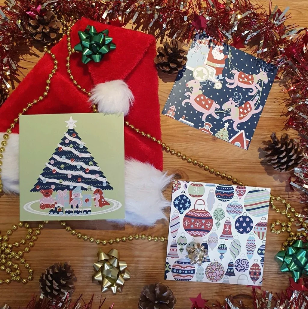 A display of Contact Christmas cards on a table with a santa hat and decorations