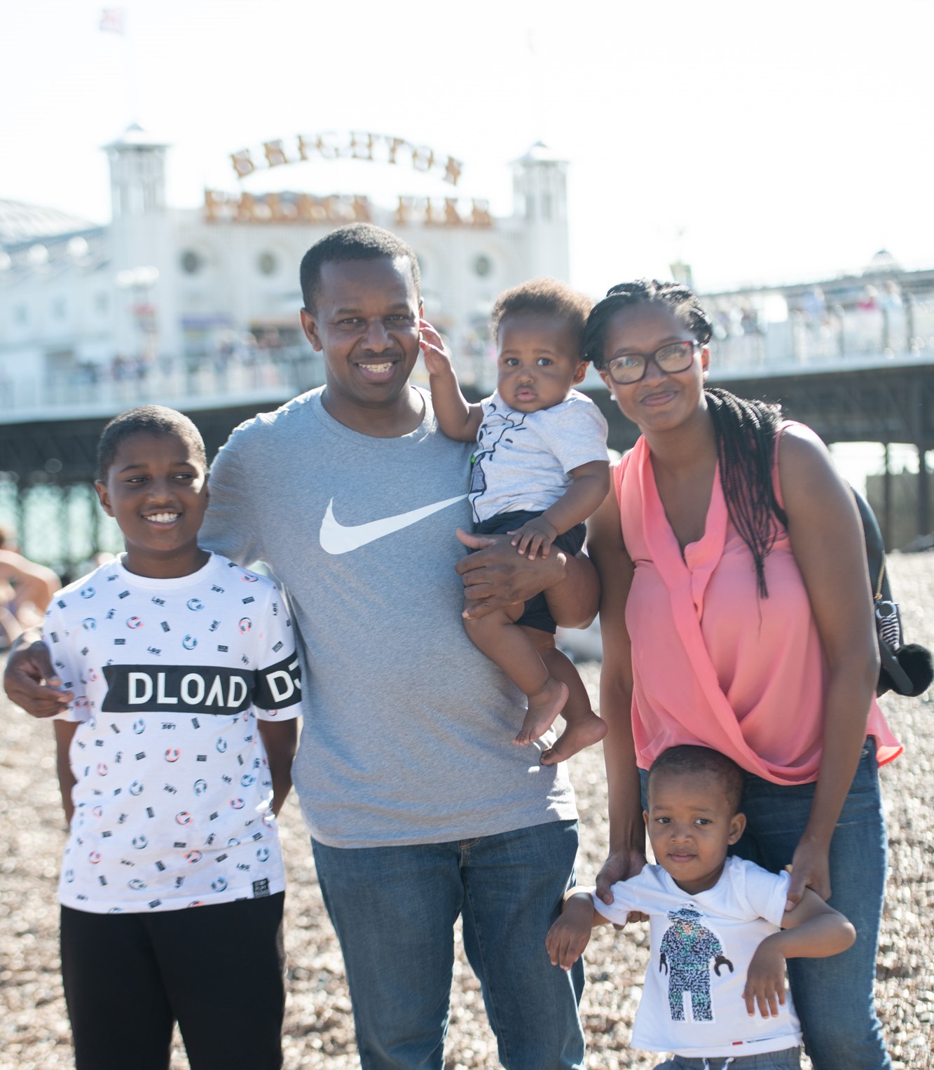 Family on Brighton Beach with Brighton Pier in background