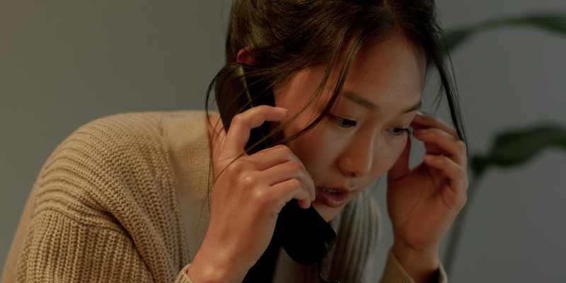 Asian woman on phone looking concerned