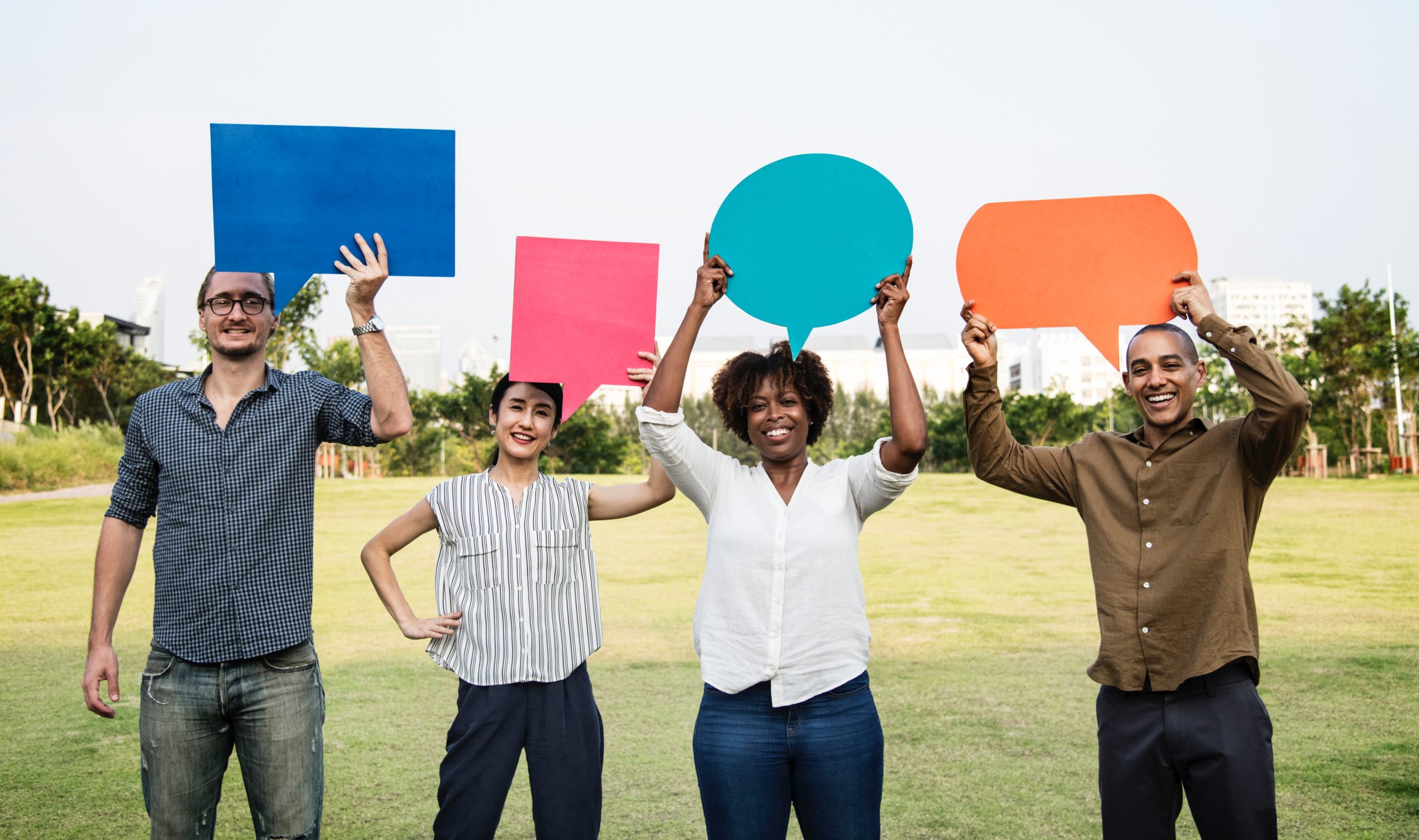 4 people holding bright coloured speech bubbles