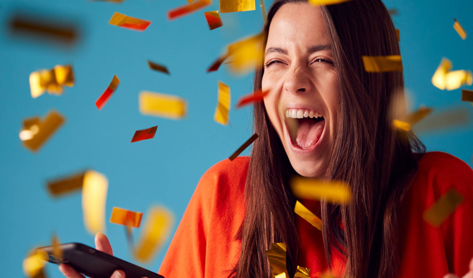 Woman celebrating in confetti after winning the lottery