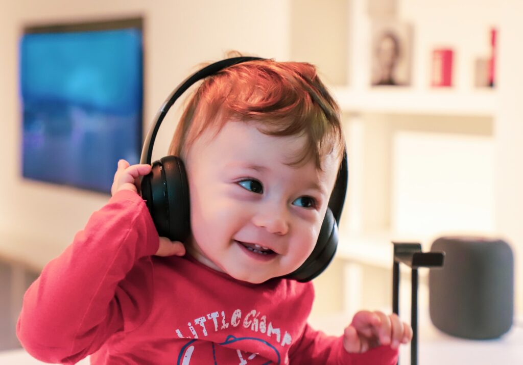 Child listening to audio through headphones and smiling