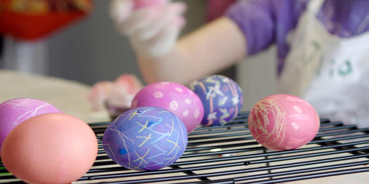 Painted eggs on an oven rack with a soft-focus child in the background