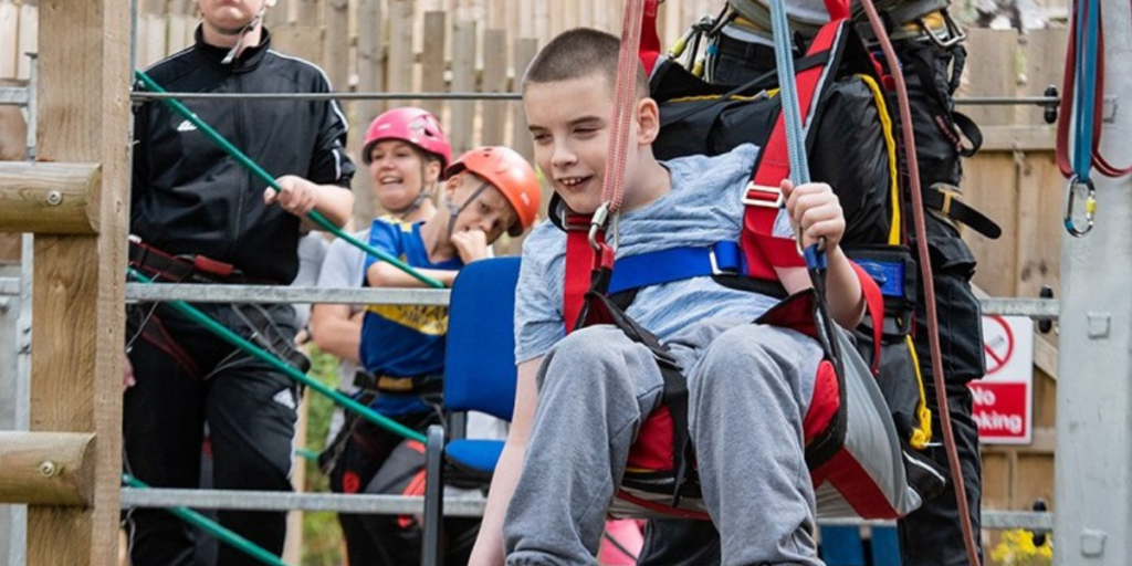 Child in a harness on a zip wire