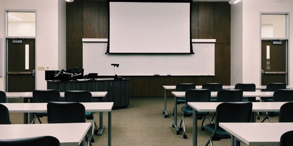 Empty classroom with rows of desks and whiteboard