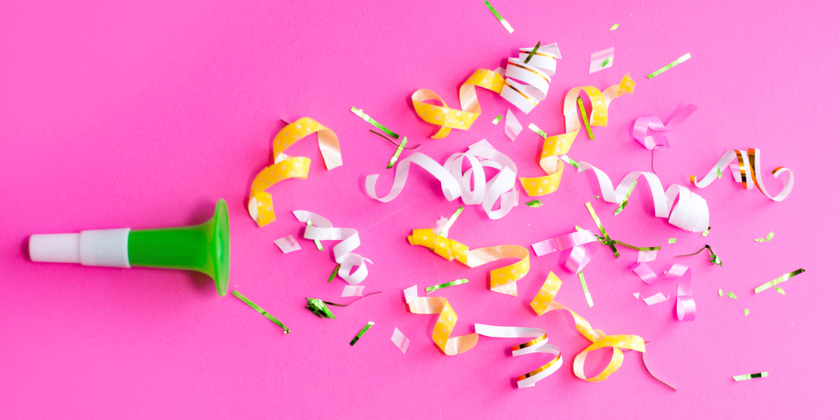 Celebratory streamers on a pink background