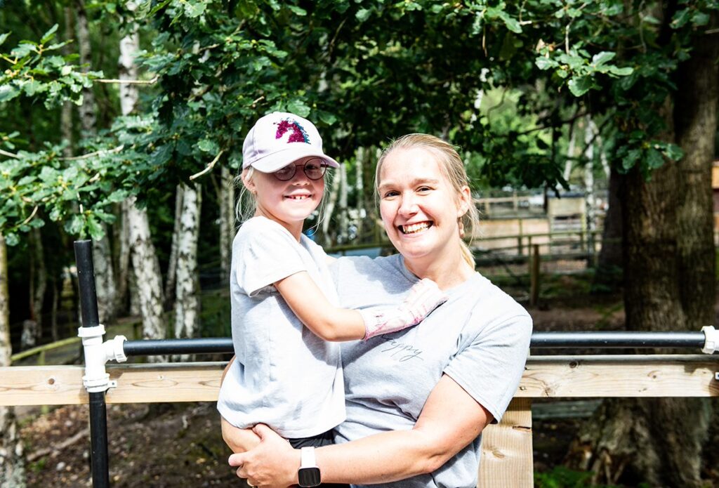 Adult holding child at adventure park
