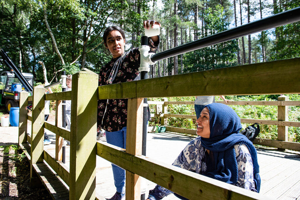 Mum and daughter feeding animals at woodland event
