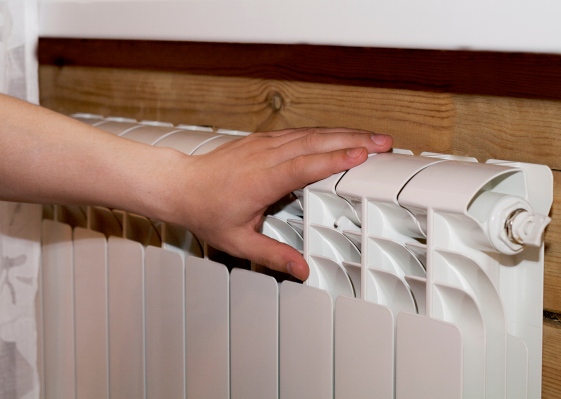 Child's hand on top of a radiator