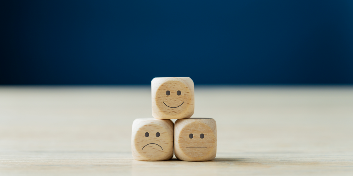 Three stacked dice with smiley faces on them demonstrating satisfaction ratings.