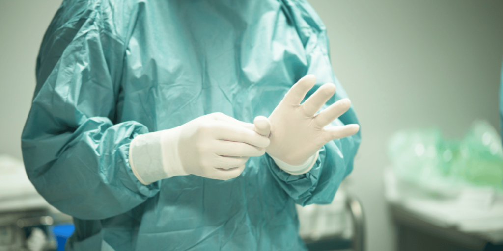 Hospital surgeon putting on gloves