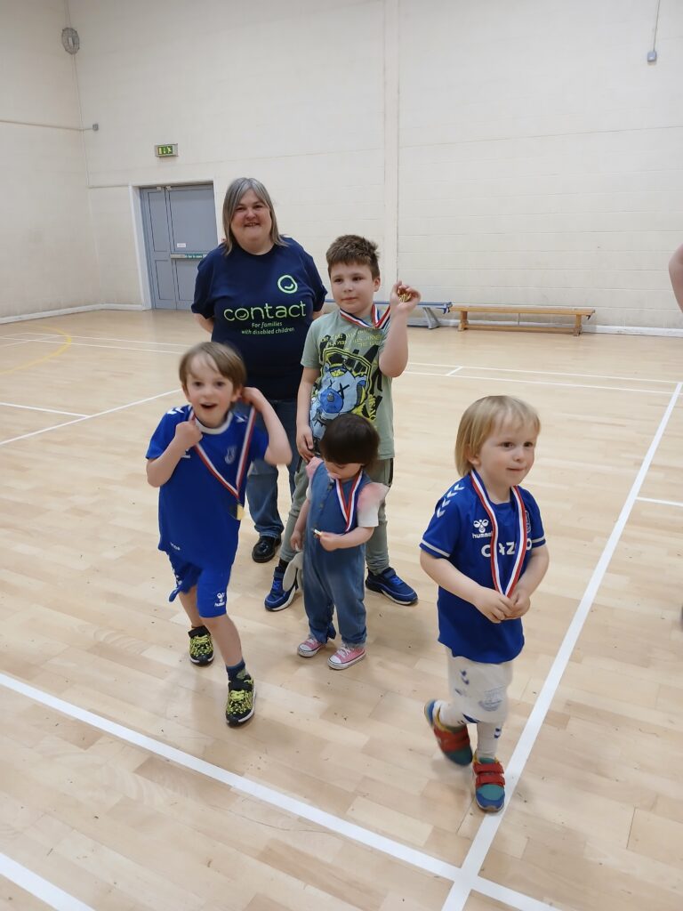 Children in a gymnasium holding medals