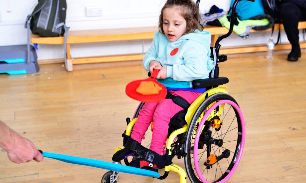 Young child in wheelchair playing sports