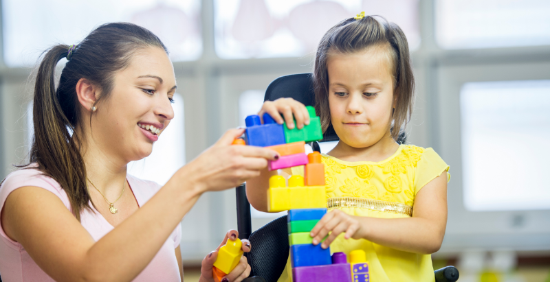 Child and teacher playing with blocks