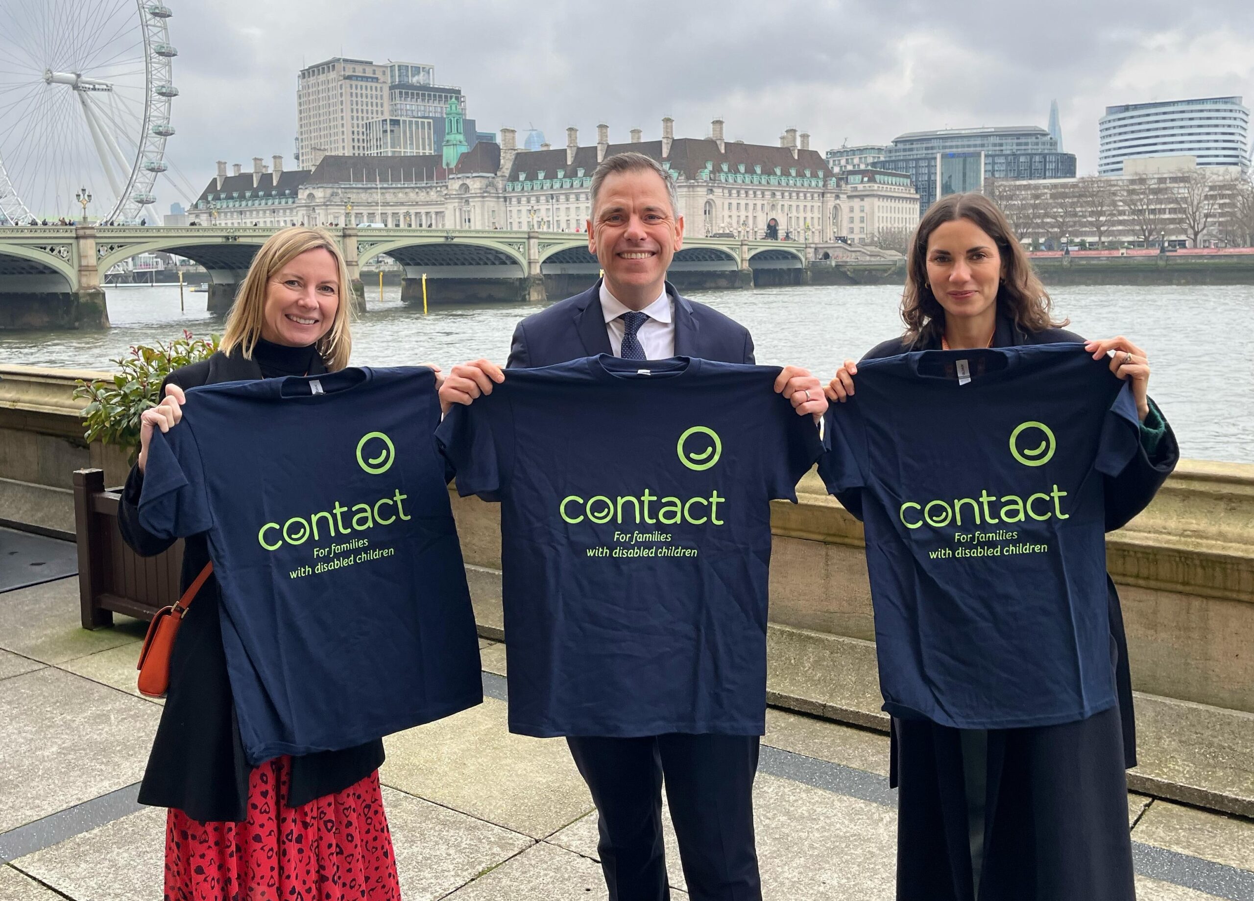 Chris Evans MP with Contact staff members Kaya and Elaine holding up Contact t-shirts on the House of Commons terrace