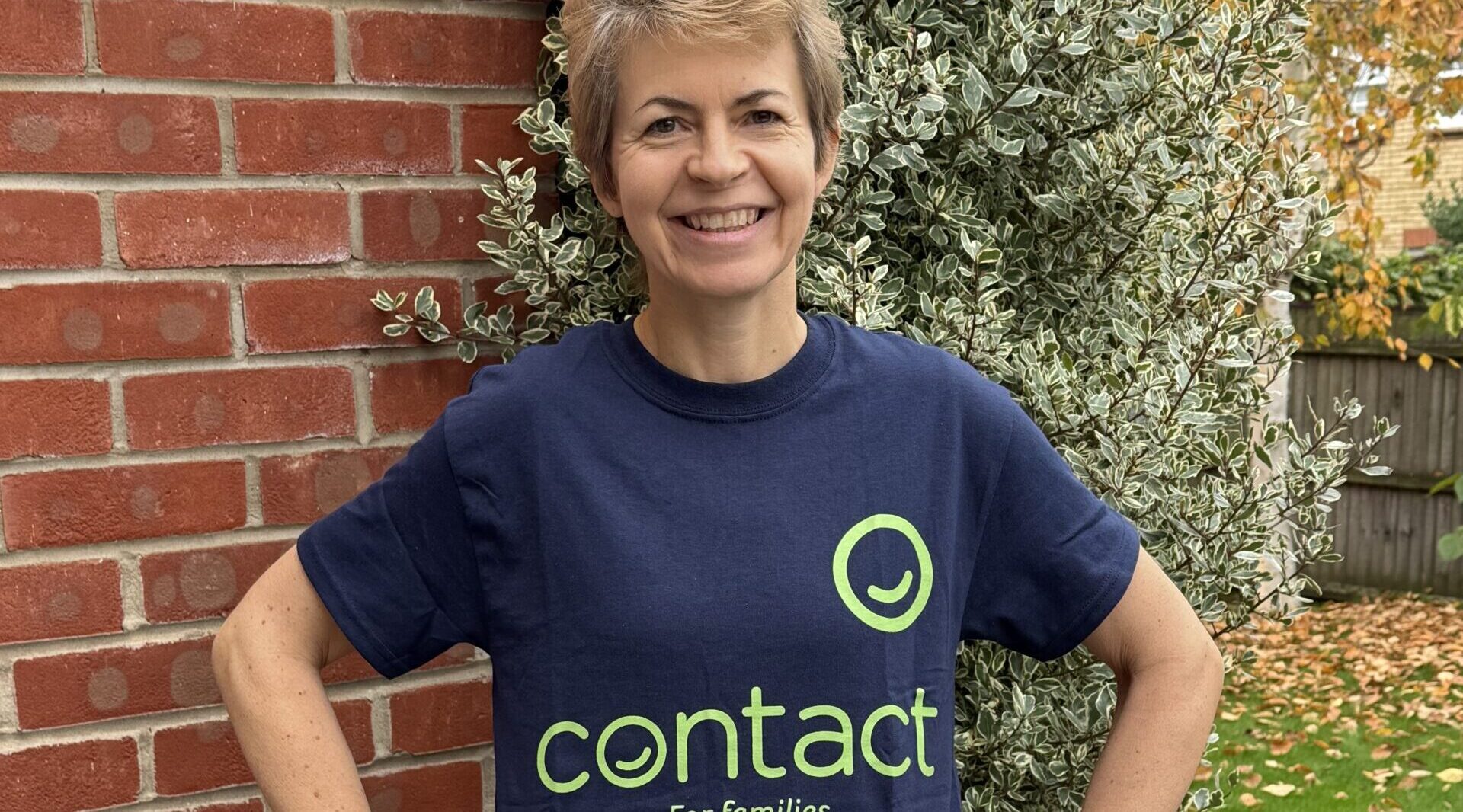 A woman in a Contact charity t shirt smiling