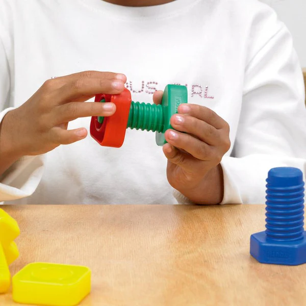 Child's hands playing with nuts and bolts toy