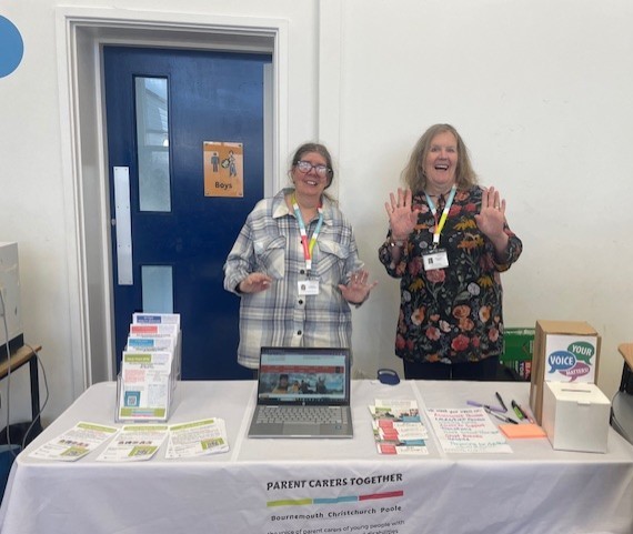 two women standing behind a promotional stand