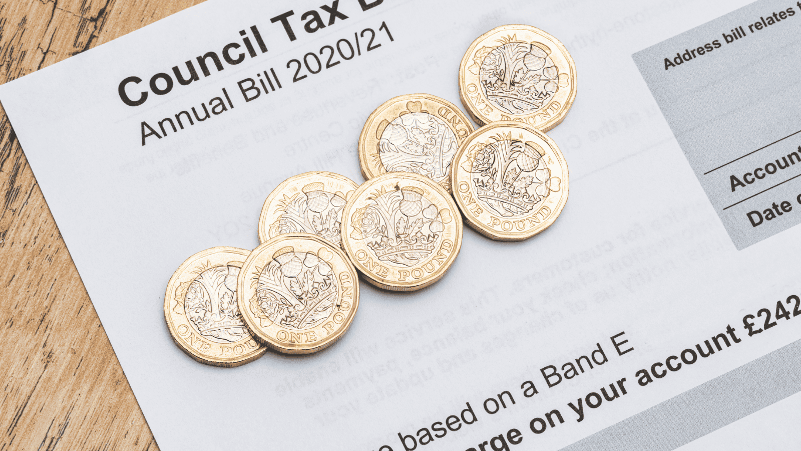 Council tax bill with some pound coins on top