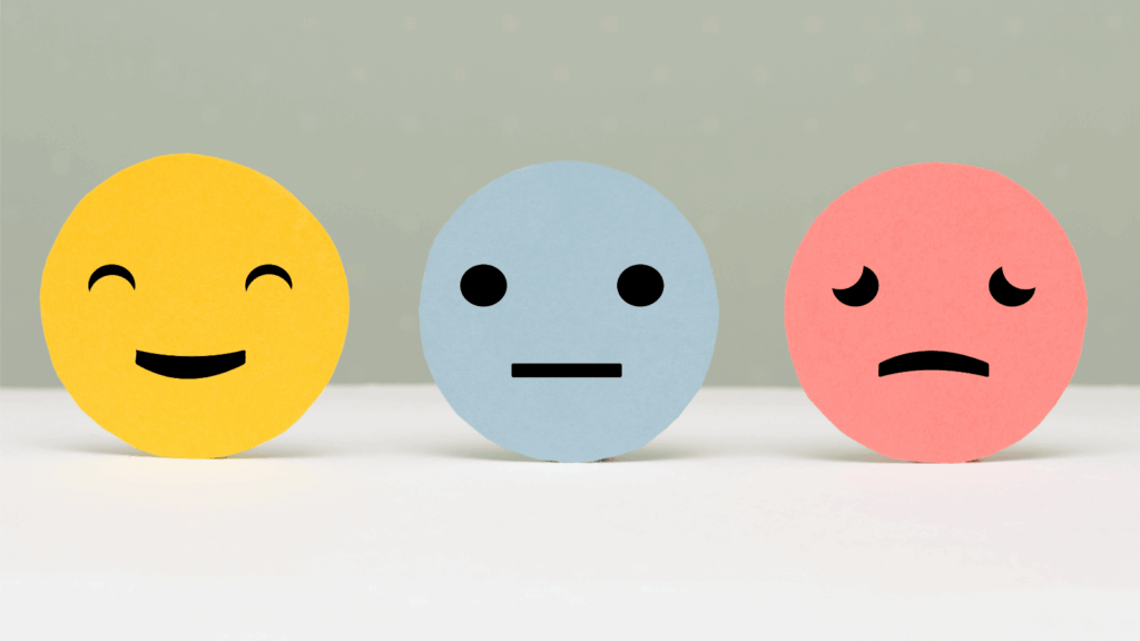 Three round emoji face graphics in a row depicting happy, neutral and unhappy.