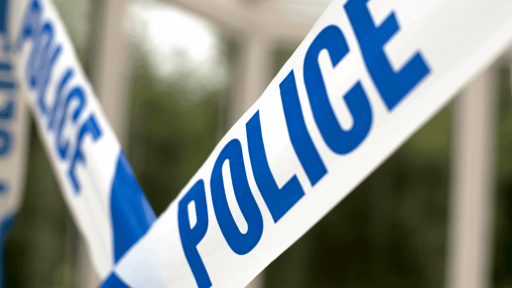 Police tape stretching across a blurry background