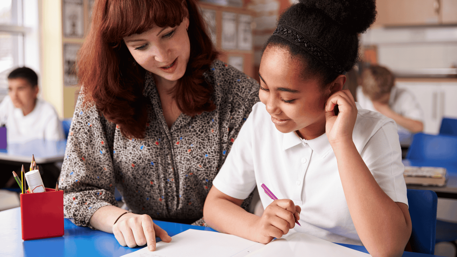 A teacher reading with a pupil