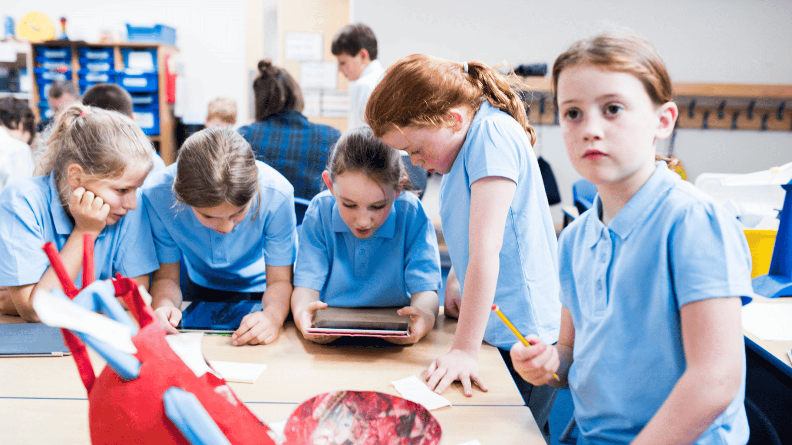 Primary school students in a science lesson wearing a blue uniform