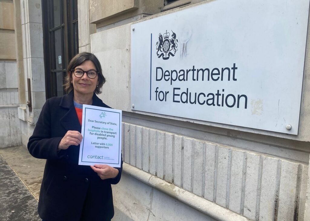 A woman stands outside the Department for Education building holding a letter addressed to the Secretary of State, requesting action for disabled children’s transport and showing support from 6,200 people.